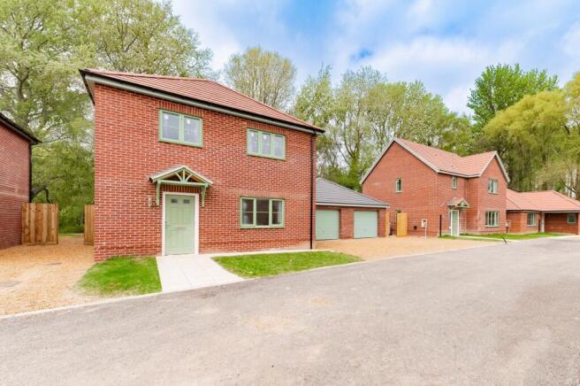 Image of a detached house for sale, nestled in the woods