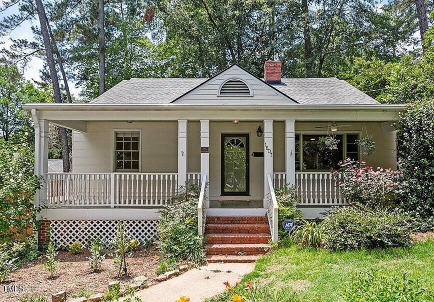 A white wooden house with a corridor in front