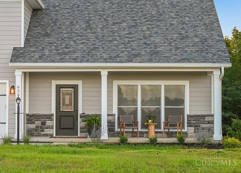 A house featuring a welcoming front porch and an attached garage