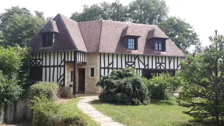 A house with a wooden roof surrounded by greenery